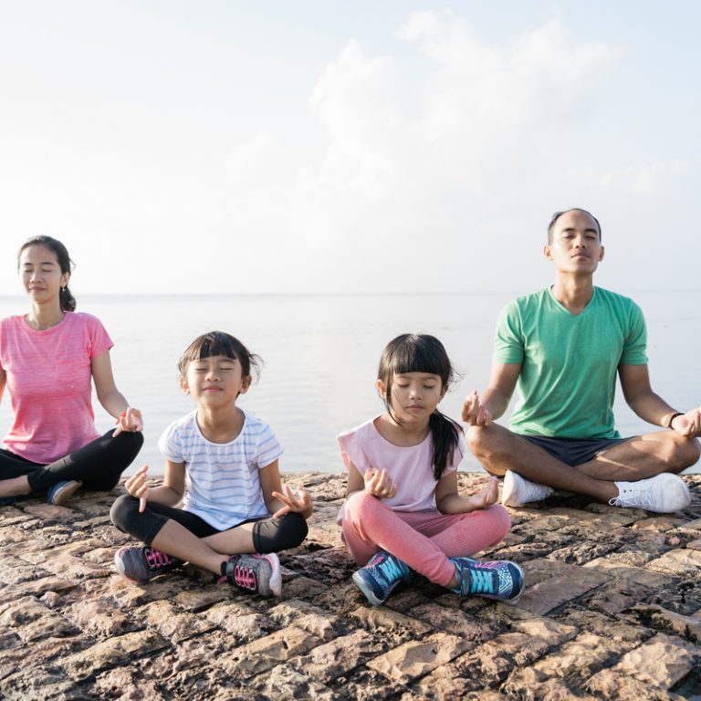 asian parent and children do sport outdoor. healthy family meditate together